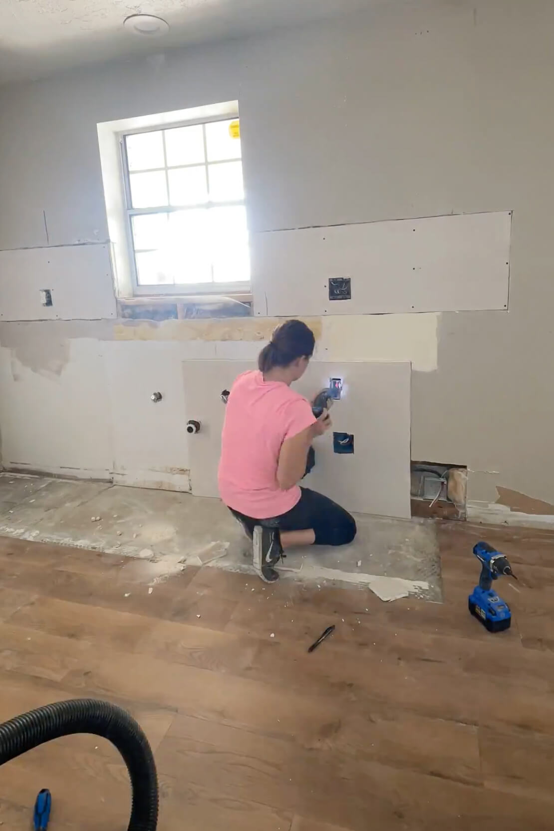 Repairing drywall during a DIY kitchen remodel.